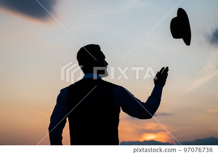 silhouette of man throeing up his hat on sunrise sky, carefree silhouette of man throeing up his hat on sunrise sky, carefree 97076736
