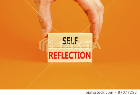 Self reflection symbol. Concept word Self reflection typed on wooden blocks. Beautiful orange table orange background. Businessman hand. Business psychological and self reflection concept. Copy space. 97077258