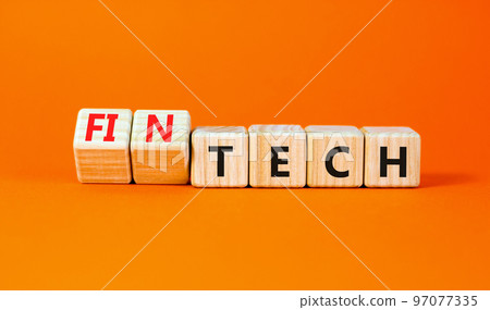 Tech or fintech symbol. Concept word Tech and Fintech on wooden cubes. Beautiful orange table orange background. Business and tech or fintech concept. Copy space. 97077335