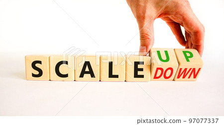 Scale up or down symbol. Concept words Scale up Scale down wooden cubes. Businessman hand. Beautiful white table white background. Business scale up or down concept. Copy space. 97077337