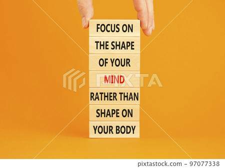 Mind or body symbol. Concept words Focus on the shape of mind rather than shape of your body on wooden blocks. Beautiful orange background copy space. Businessman hand. Business mind or body concept. Mind or body symbol. Concept words Focus on the shape of mind rather than shape of your body on wooden blocks. Beautiful orange background copy space. Businessman hand. Business mind or body concept. 97077338