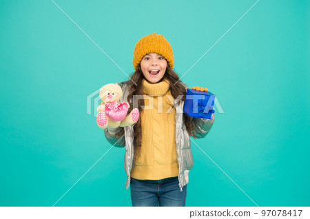 i want both. shopping online with extra bonus. small girl surprised about xmas present. gift with love. merry christmas. happy new year. gift for winter holidays. stylish kid in warm winter clothes 97078417