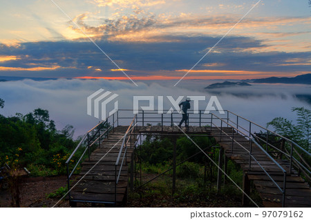 Man traveler enjoying mist viewpoint on the mountain at Nong Khai province, Thailand Man traveler enjoying mist viewpoint on the mountain at Nong Khai province, Thailand 97079162