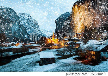 amazing touristic alpine village at night in winter with famous church and Staubbach waterfall Lauterbrunnen Switzerland Europe amazing touristic alpine village at night in winter with famous church and Staubbach waterfall Lauterbrunnen Switzerland Europe 97080843