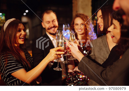Cheering and drinking cocktails. Group of friends partying in a nightclub and toasting drinks cocktails. Cheering and drinking cocktails. Group of friends partying in a nightclub and toasting drinks cocktails. 97080979