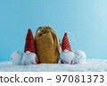 Christmas or winter composition. Two gnomes with a bag of gifts in the snow. 97081373