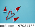 Christmas, New Year blue stylish flat frame with lollipops and santa claus hat. Winter holiday composition. 97081377