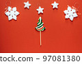 Christmas or winter composition. Frame made of snowflakes and candy trees on a red background. Christmas, winter, new year concept. Flat lay 97081380