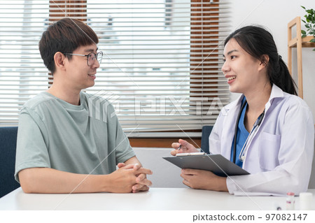 Female doctor physician is taking notes on clipboard and writing prescription while asking symptom 97082147