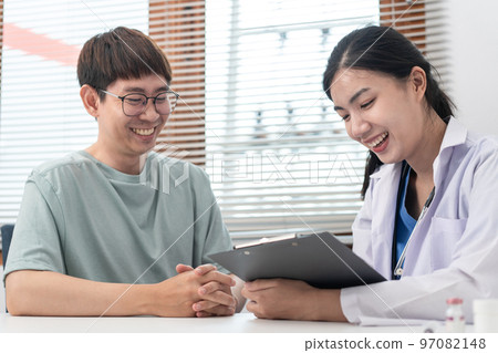 Female doctor physician is taking notes on clipboard and writing prescription while asking symptom Female doctor physician is taking notes on clipboard and writing prescription while asking symptom 97082148