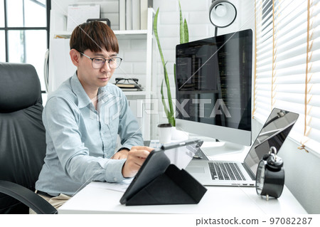 Male programmer is working to checking program code and debugging on tablet while programing 97082287