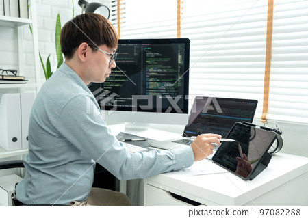 Male programmer is working to checking program code and debugging on tablet while programing 97082288