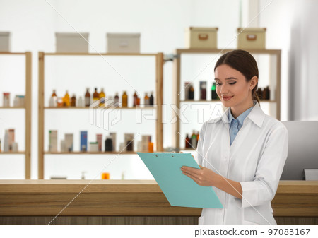 Professional pharmacist with clipboard in drugstore. Space for text 97083167