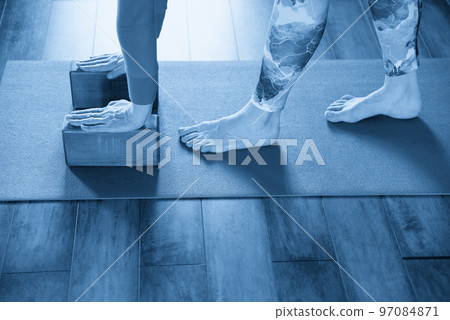 Women practicing yoga stretching using wooden blocks with hands, exercise for spine and shoulders flexibility Women practicing yoga stretching using wooden blocks with hands, exercise for spine and shoulders flexibility 97084871