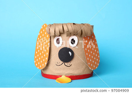 Toy dog made of toilet paper roll on light blue background Toy dog made of toilet paper roll on light blue background 97084909