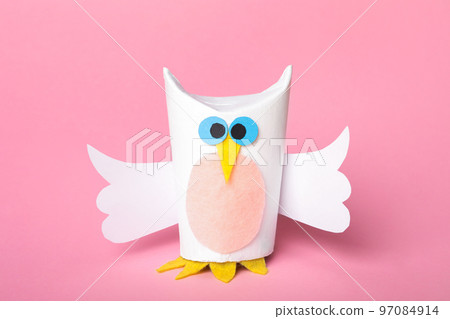 Toy owl made of toilet paper hub on pink background 97084914
