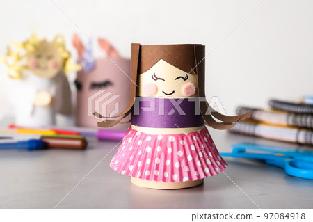 Toy doll made of toilet paper hub on grey table Toy doll made of toilet paper hub on grey table 97084918
