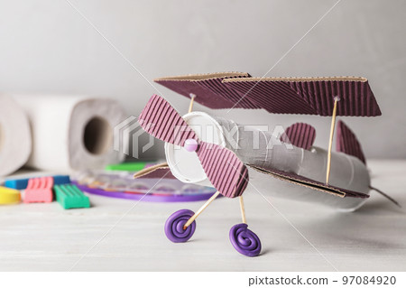 Toy plane made of toilet paper hub on white wooden table 97084920