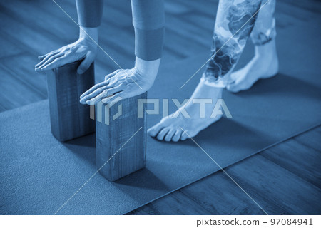 Women practicing yoga stretching using wooden blocks with hands, exercise for spine and shoulders flexibility 97084941