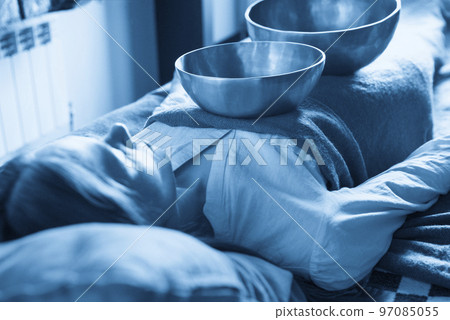 Tibetan singing bowls in sound therapy in spa center over a woman body 97085055