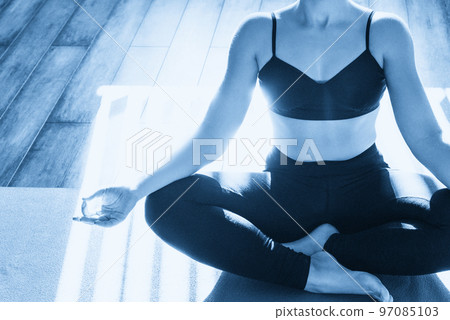 Young woman meditating sitting in lotus position with copy space 97085103