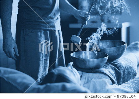 Tibetan singing bowls with smoke in sound therapy in spa center 97085104
