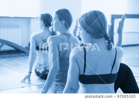 Women Relaxing and Doing Yoga pose. Wellness and Healthy Lifestyle concept 97085105