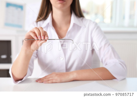 Speech therapist with logopedic probe in clinic, closeup 97085717