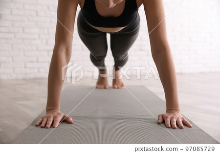 Young woman practicing plank asana in yoga studio, closeup. Phalankasana pose Young woman practicing plank asana in yoga studio, closeup. Phalankasana pose 97085729