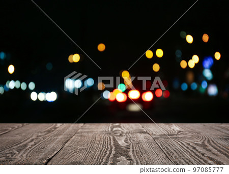 Empty wooden surface against blurred lights. Bokeh effect 97085777