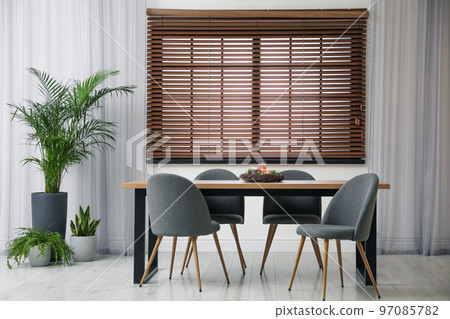 Modern wooden table with burning candles in room interior Modern wooden table with burning candles in room interior 97085782