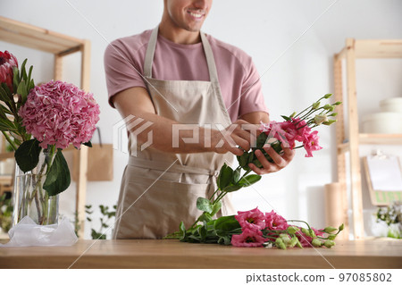 Florist making beautiful bouquet at table in workshop, closeup Florist making beautiful bouquet at table in workshop, closeup 97085802