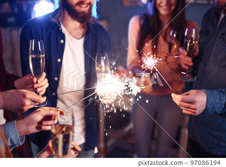 Group of friends having fun with sparklers. young people laugh. celebrating New Year together. 97086194