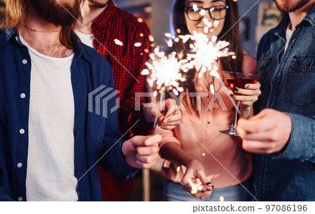 Group of friends having fun with sparklers. young people laugh. celebrating New Year together. Group of friends having fun with sparklers. young people laugh. celebrating New Year together. 97086196