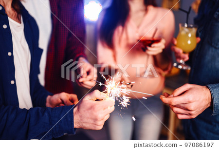 Group of friends having fun with sparklers. young people laugh. celebrating New Year together. Group of friends having fun with sparklers. young people laugh. celebrating New Year together. 97086197