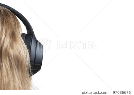 Woman in headphones isolated on white. Black headphones on a woman's head. Head of a fair-haired woman in headphones, rear view close-up. Woman in headphones isolated on white. Black headphones on a woman's head. Head of a fair-haired woman in headphones, rear view close-up. 97086676