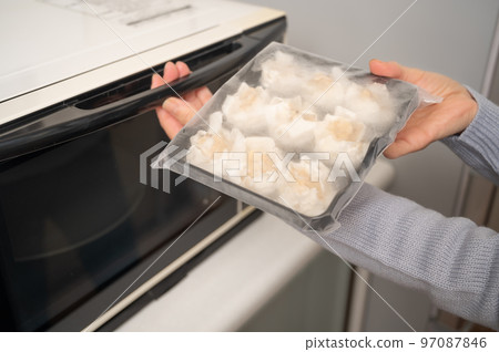 用微波爐重新加熱冷凍的燒賣 用微波爐重新加熱冷凍的燒賣 97087846