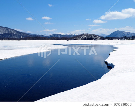 裡磐梯的檜原湖早春。雪原融化，出現湛藍的湖水，倒映著白雲和藍天，與殘雪相映成趣。 97089063