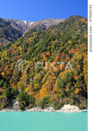 Ichidaira, Omachi, Nagano Prefecture: The bright emerald green leaves of the Takase Dam Regulating Lake and the light snow-capped peaks of the mountains Ichidaira, Omachi, Nagano Prefecture: The bright emerald green leaves of the Takase Dam Regulating Lake and the light snow-capped peaks of the mountains 97089591