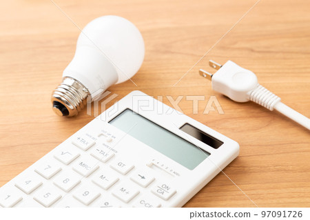 Calculator and outlet plug on the desk, wood grain background Calculator and outlet plug on the desk, wood grain background 97091726