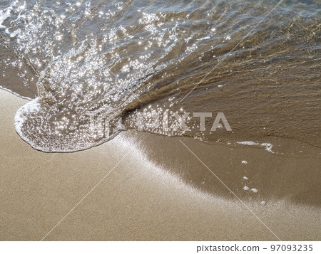 The gentle waves of the sandy beach that reflect the sunlight and sparkle. The gentle waves of the sandy beach that reflect the sunlight and sparkle. 97093235