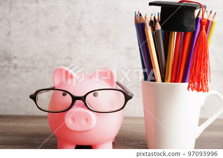 Pigging bank wearing eyeglass with coins and calculator saving bank education concept. 97093996