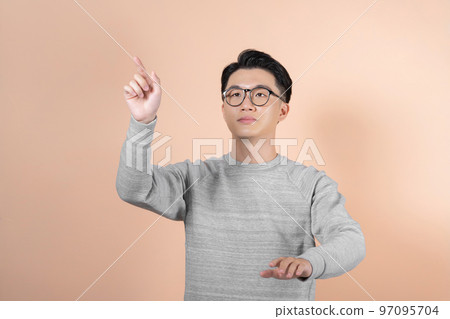 A smart looking man looks up and holds his hands as if manipulating a large touch screen A smart looking man looks up and holds his hands as if manipulating a large touch screen 97095704