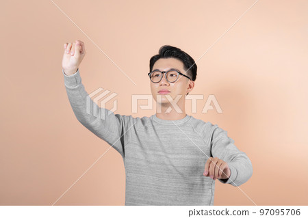 Portrait of thoughtful businessman using virtual screen on beige background Portrait of thoughtful businessman using virtual screen on beige background 97095706