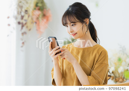 A woman watching a smartphone A woman watching a smartphone 97098241