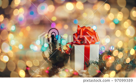green fir branches on the wooden floor with gifts with Christmas. beautiful bokeh effect from a garland. green fir branches on the wooden floor with gifts with Christmas. beautiful bokeh effect from a garland. 97099389