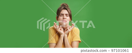 Worried intense, concerned attractive young european female model in yellow t-shirt raising shoulders crossing fingers for good luck pursing lips and closing eyes while waiting for miracle hopefully Worried intense, concerned attractive young european female model in yellow t-shirt raising shoulders crossing fingers for good luck pursing lips and closing eyes while waiting for miracle hopefully 97101061