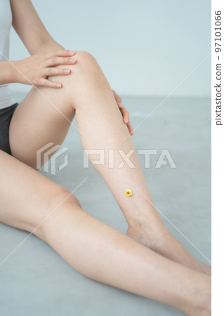 A woman doing moxibustion on her leg 97101066