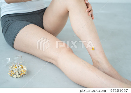 A woman doing moxibustion on her leg 97101067