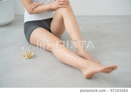 A woman doing moxibustion on her leg 97101068